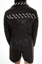 Model wearing The Edge-Laced Jacket by Chez Neeba — cropped black leather jacket with white lace-up detailing, limited edition Dubai fashion.