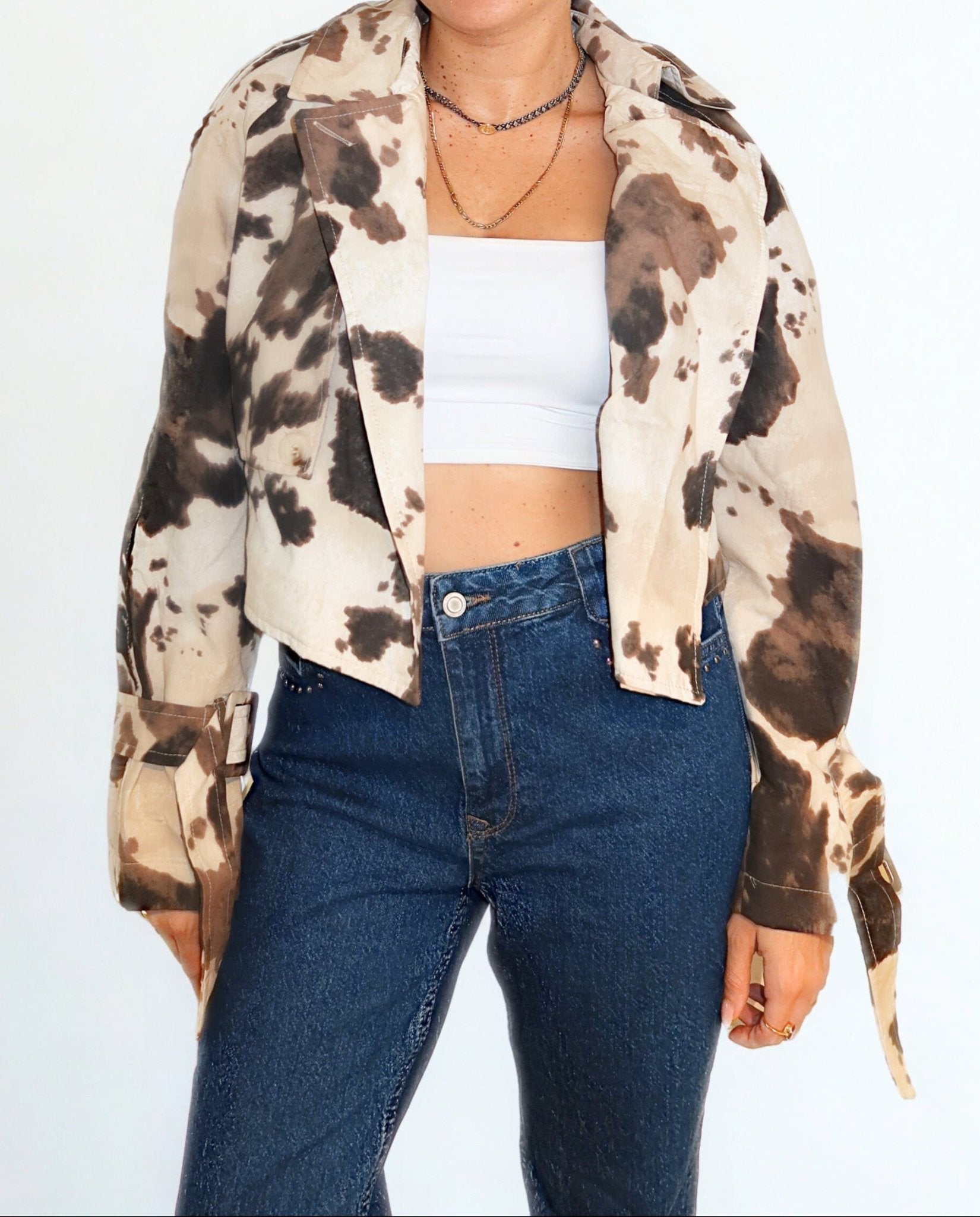 Model wearing cow print trench jacket by Chez Neeba — limited edition women’s fashion from Dubai.